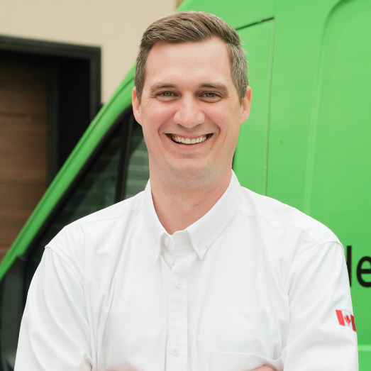 Furnasman technician standing by our famous green trucks in a residential neighbourhood.